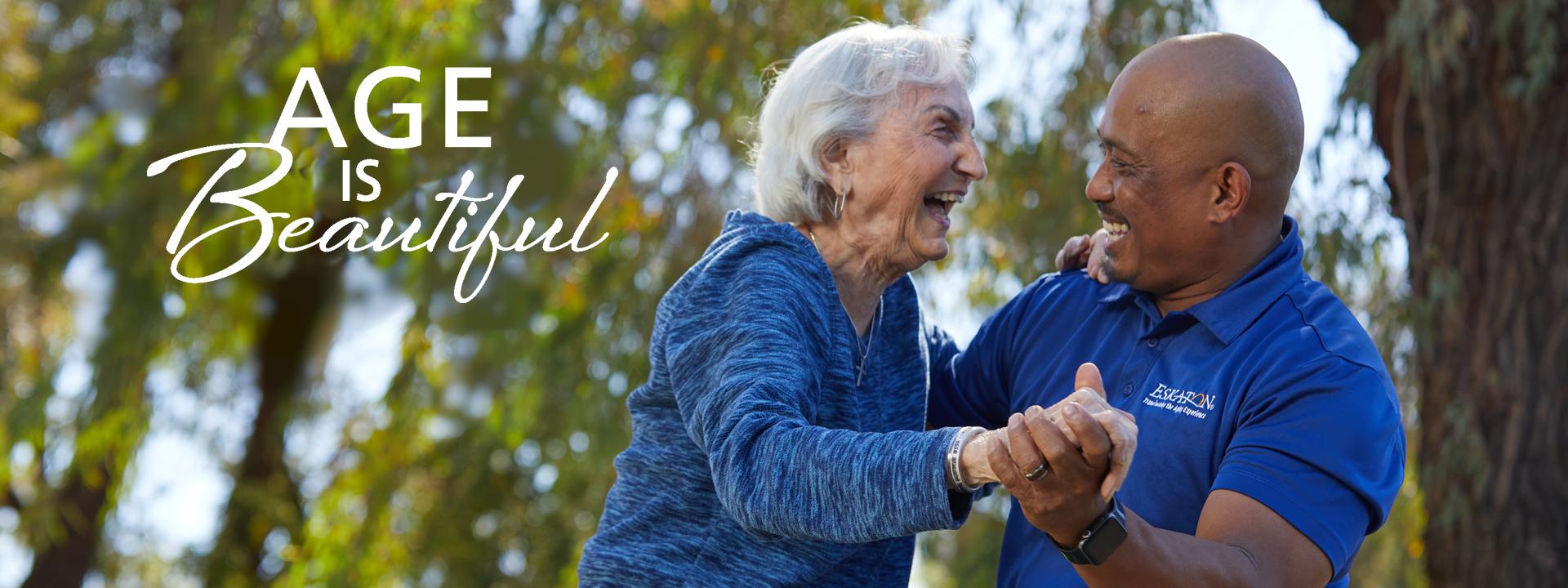 Resident and staff smiling and dancing outside