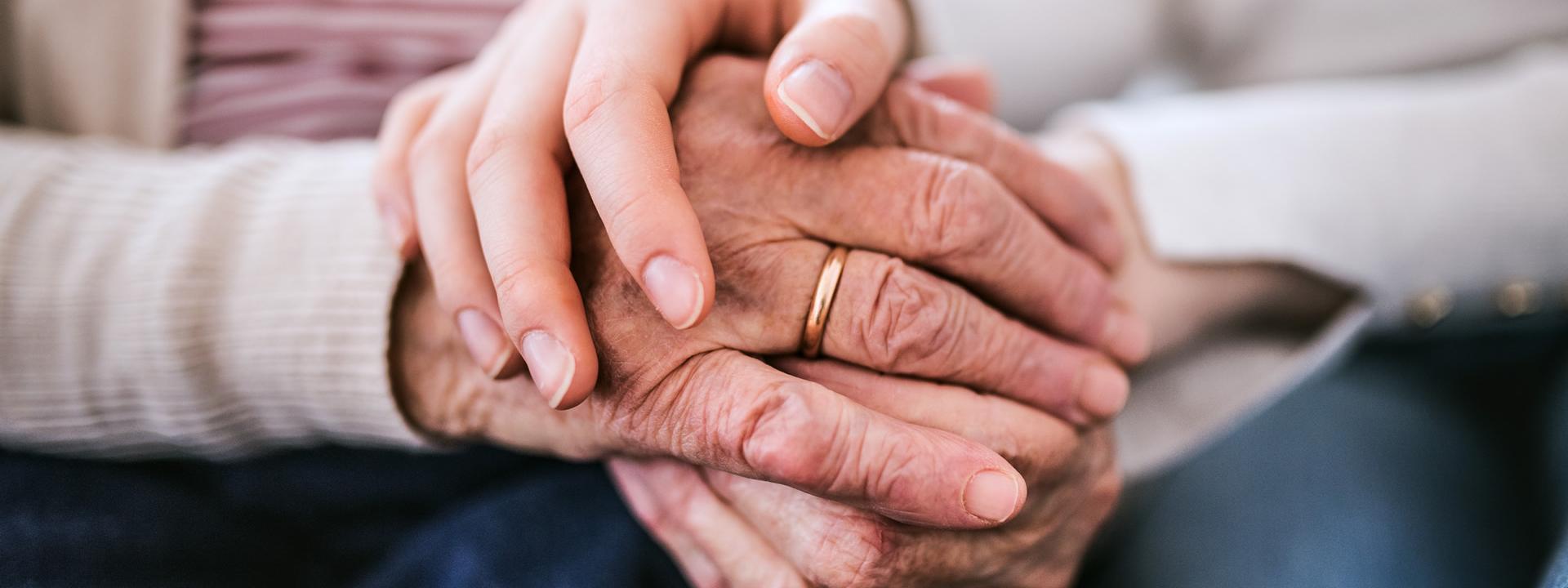 Two holding hands, one older and one younger.