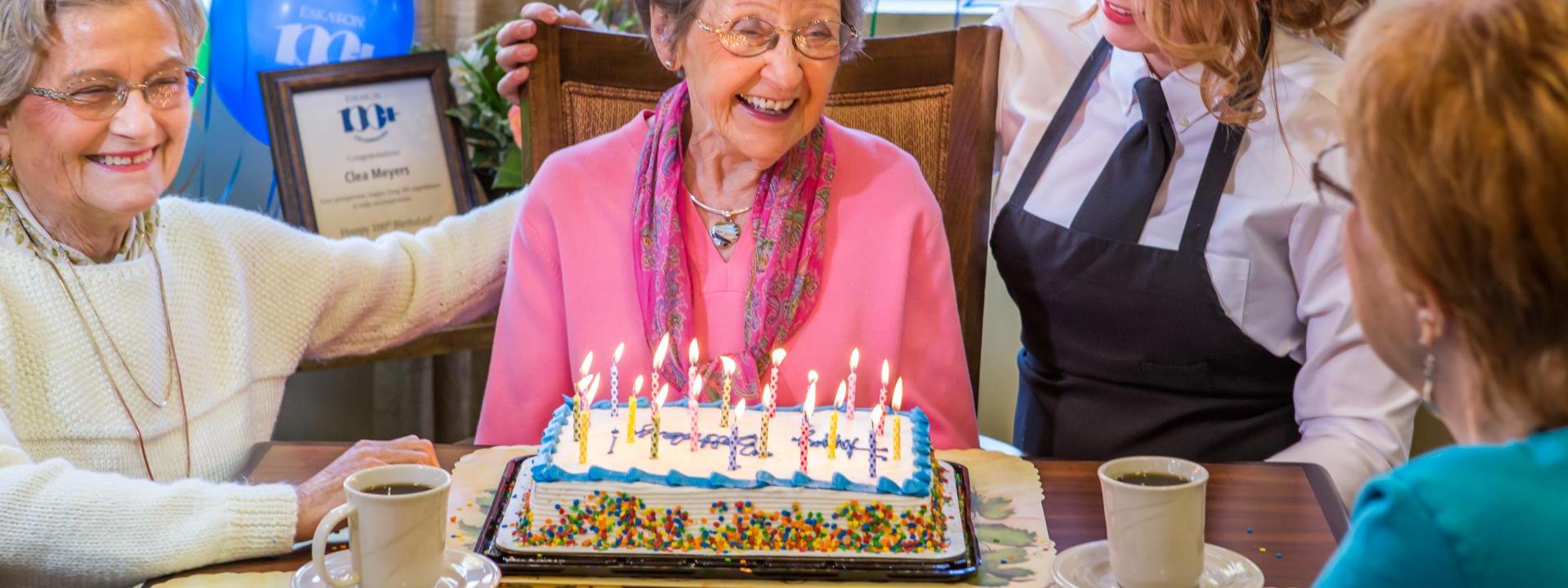 woman celebrating her 100th birthday with friends