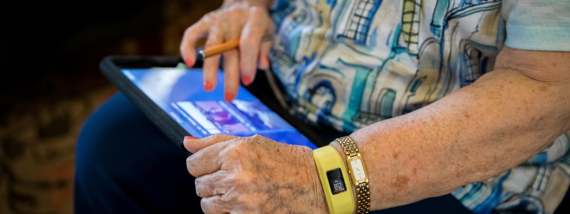 Resident using her iPad and wearing a smart watch.