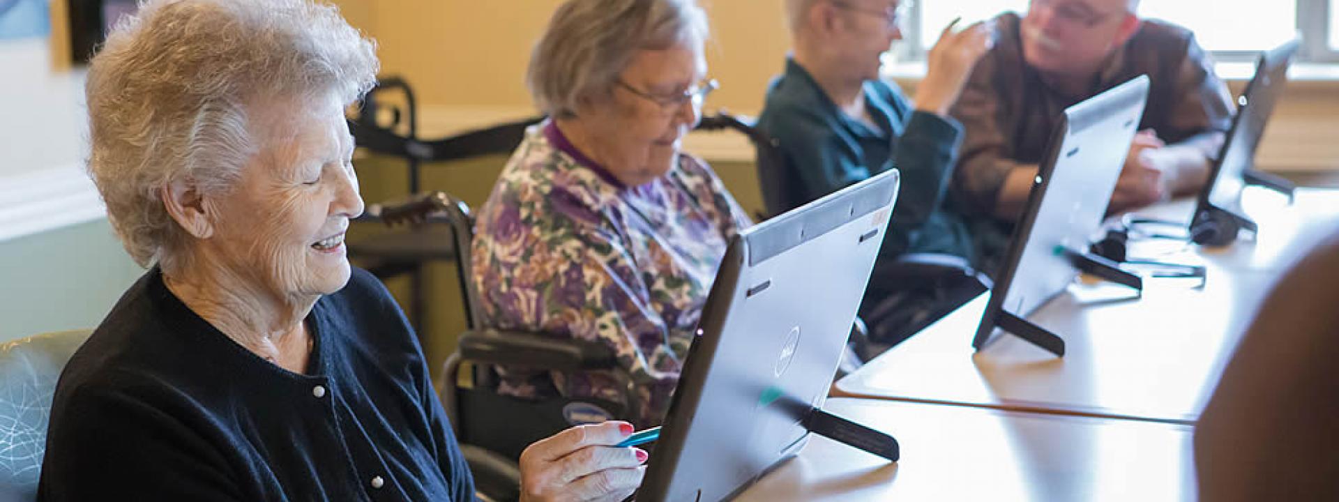 Three women residents using iPads during a computer class