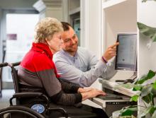 Staff teaching resident how to use the computer and some programs.