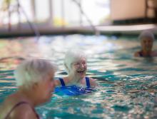 Residents enjoying a water aerobics class in the community indoor pool.