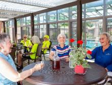 A group of residents sitting at a patio table enjoying some ice tea
