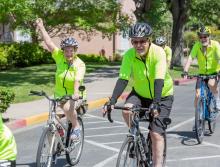 A group of residents, in their bright green shirts, riding their bikes