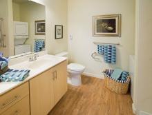 Beautifully decorated bathroom with blue stripped towels and basket