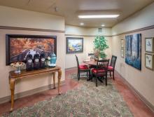 Cozy sitting area with table and four chairs, and a table with refreshments to eat and drink
