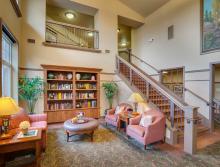 Lobby area with a couch and two chair and  book shelves with several books
