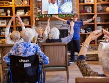 Staff member leading an exercise class with group of residents