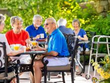 Six residents having breakfast on patio.