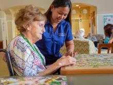 Two women putting a puzzle together in the activity room.