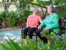 Two Eskaton Monroe Lodge women residents socializing around spa  patio area.