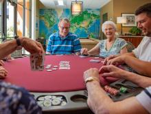 happy and smiling residents play a game of poker