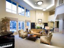 Front lobby area with couch, chairs, fireplace and piano.