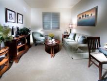 Apartment living room with a couch, chair, coffee table and end tables.