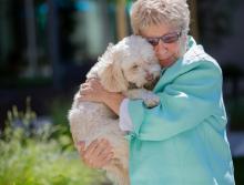 Resident holding and hugging her dog