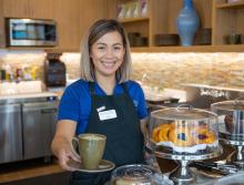 Staff offering a cup of coffee at the Bistro Cafe