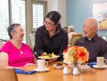 Smiling couple being served lunch in dining room