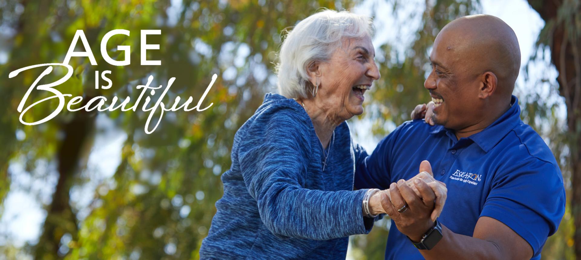Resident and staff smiling and dancing outside