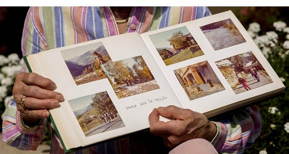 Inge holding a photo album of as a young child where her and her family lived.