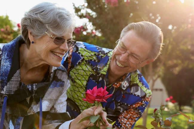 Age Is Beautiful Virgil and Lynn Nelson smelling a beautiful red rose.