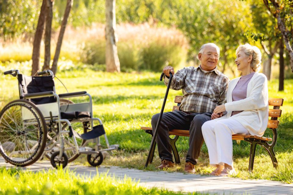 Two women sitting at the patio smiling and talking with a staff member