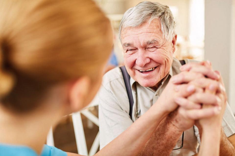 Staff with her arm around a resident and both smiling