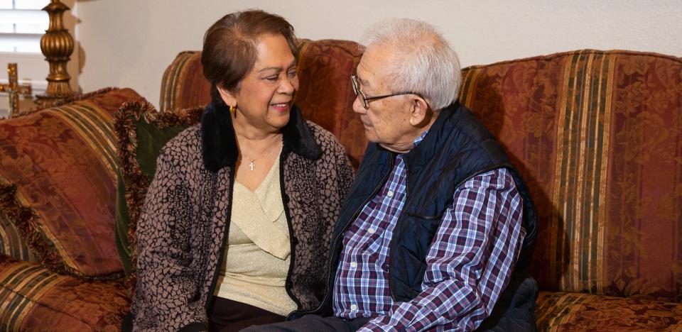 Couple sitting on the couch smiling at each other