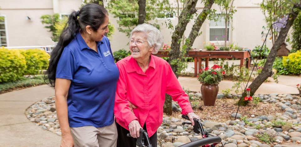 Female staff and a female resident taking a walk through the gardens