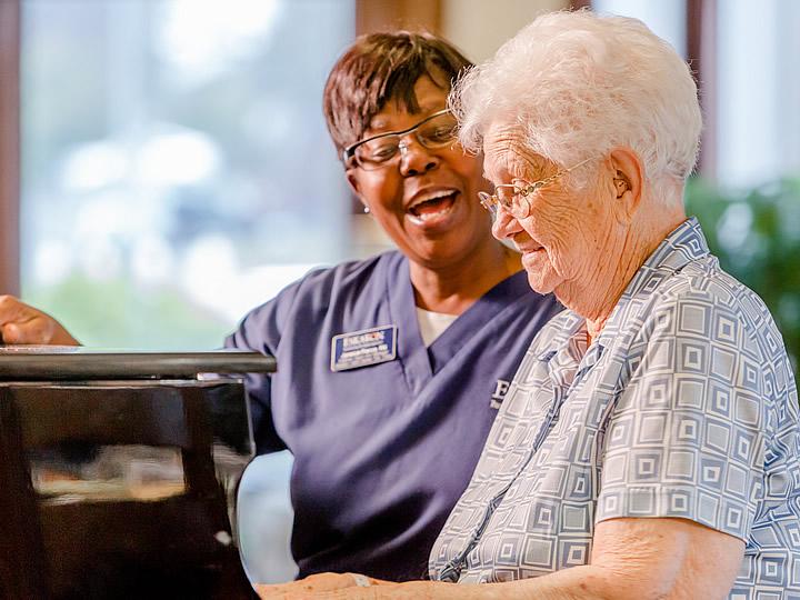 Resident playing the piano while staff sings