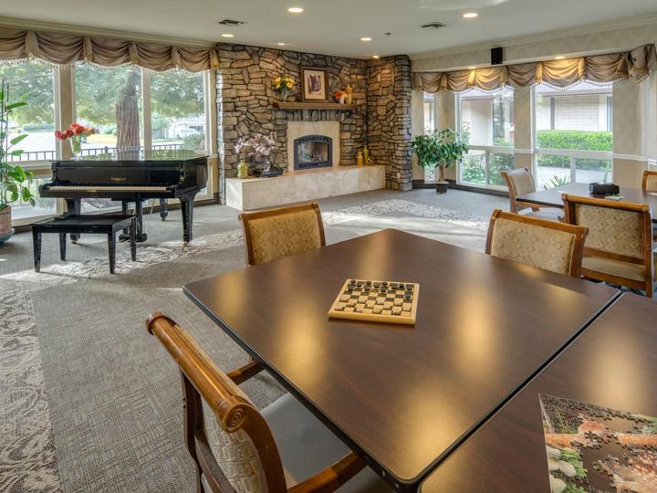Community recreation room with piano and fireplace