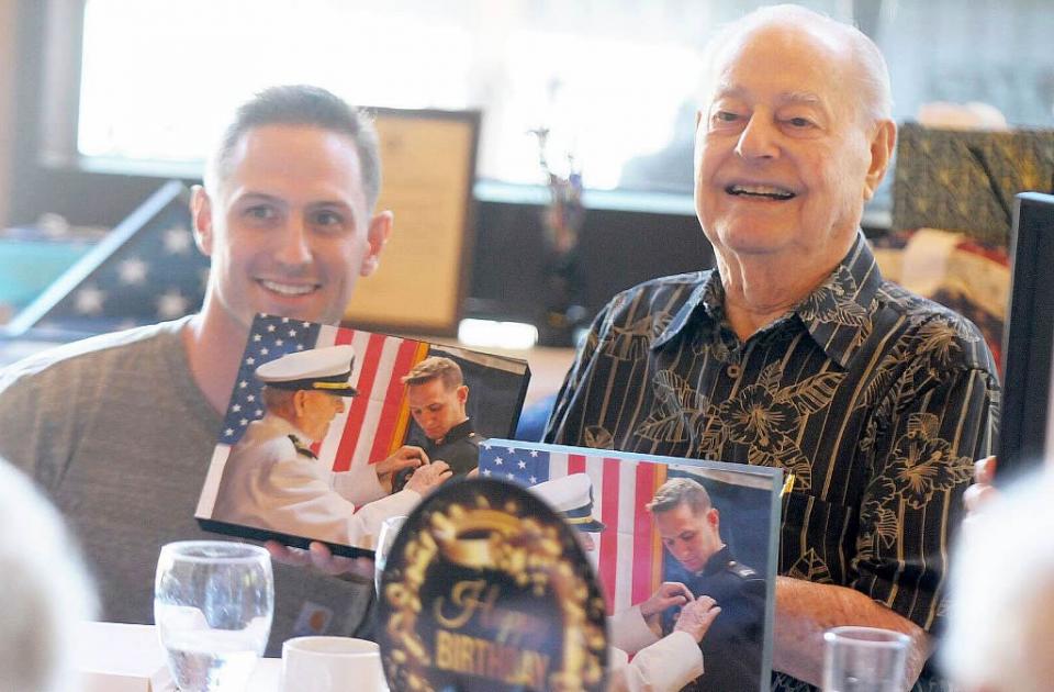Retired Lt. Cmdr. Lou Conter is presented a pair of photographs of him pinning his wings on his great-nephew, Capt. Ray Hower of the USMC.