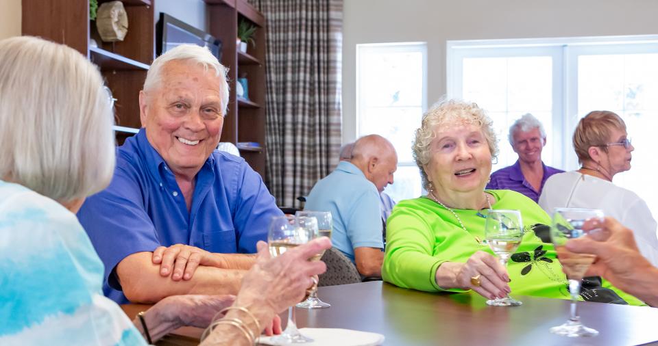 Residents enjoying a glass of wine at a social event.