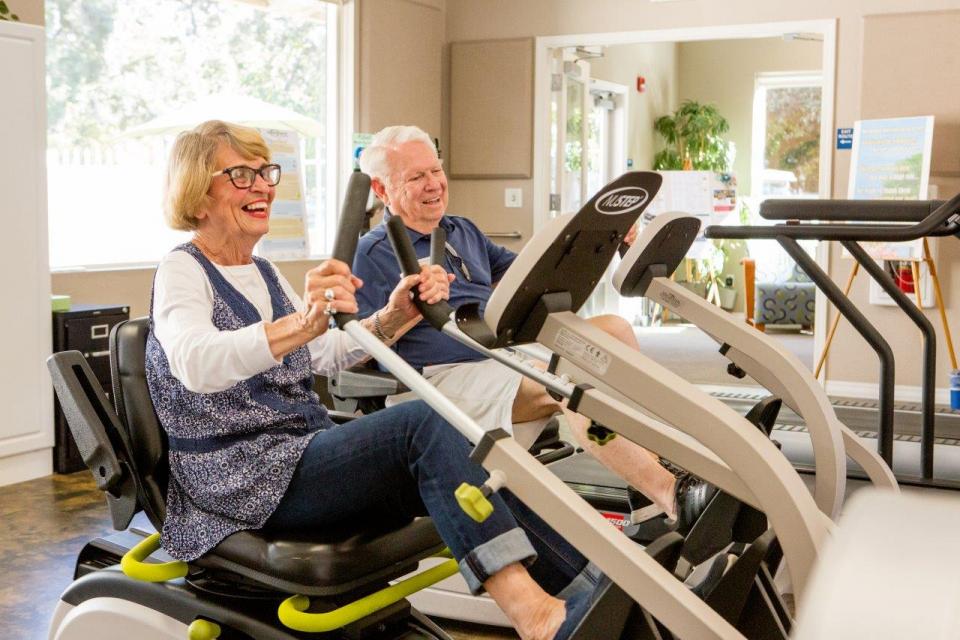 Couple working out in the gym on stationary bikes