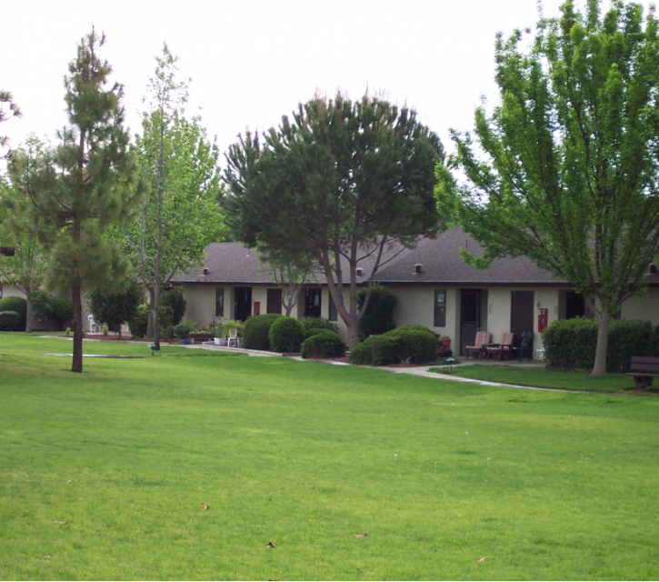 Exterior of Eskaton Kennedy Manor's apartments with beautiful trees and green lawn.