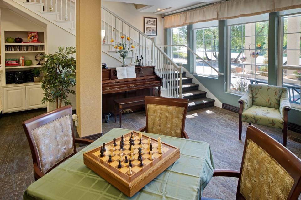Game area with a Chess set on a table and a piano.