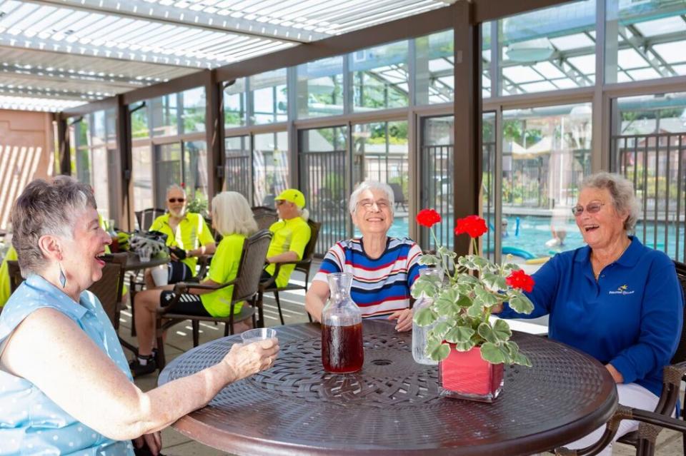 A group of residents sitting at a patio table enjoying some ice tea