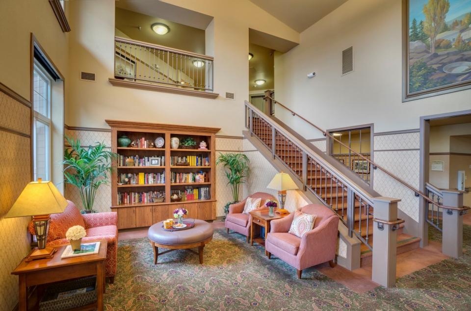 Lobby area with a couch and two chair and  book shelves with several books