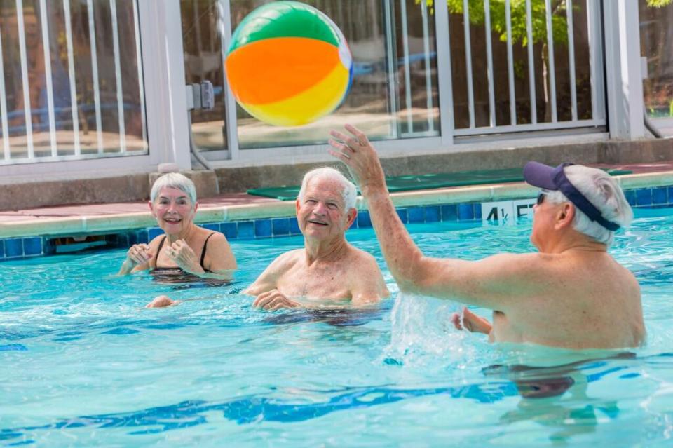 Residents in the in-door swimming pool tossing a beach ball to each other.