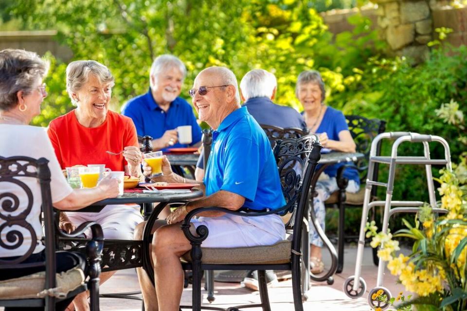 Six residents having breakfast on patio.