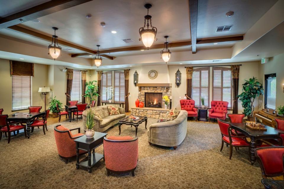 Village Center's community room with couches, chairs game tables and fireplace.