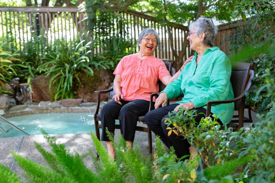 Two Eskaton Monroe Lodge women residents socializing around spa  patio area.