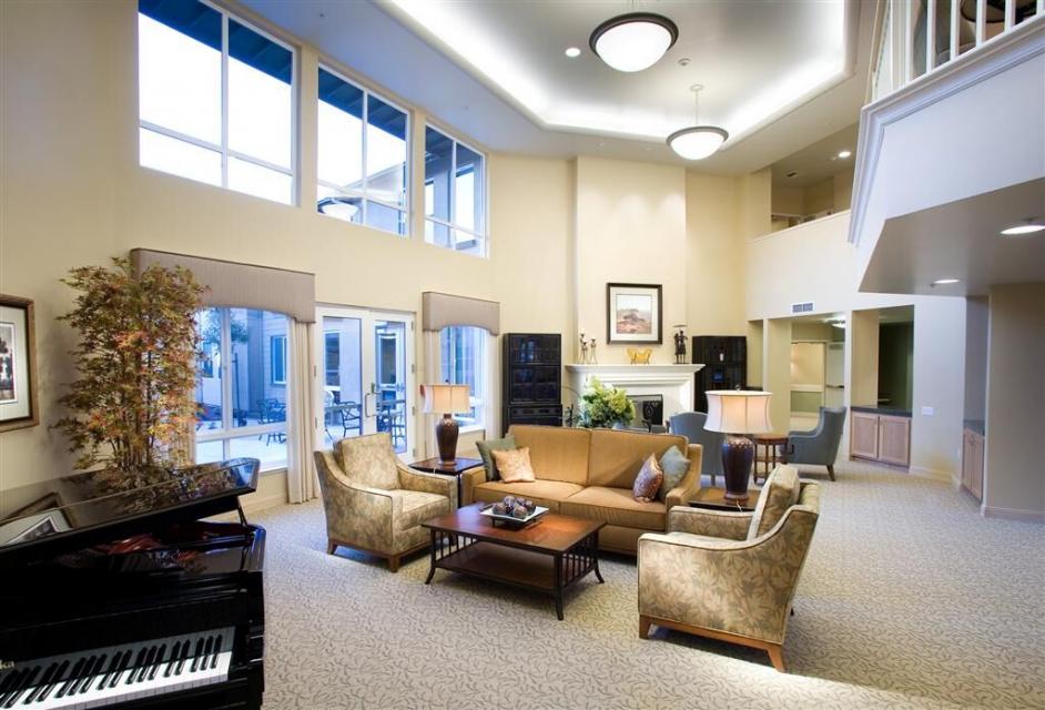 Front lobby area with couch, chairs, fireplace and piano.