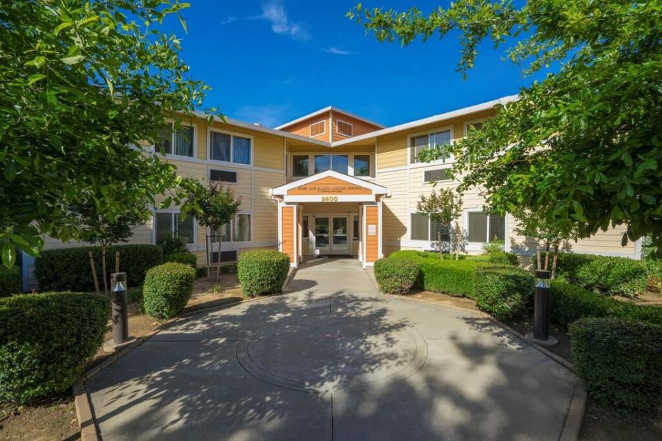 Eskaton Natomas Manor front entrance with green trees and bushes.