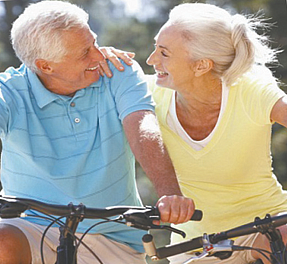 Senior couple riding their bikes and smiling at each other