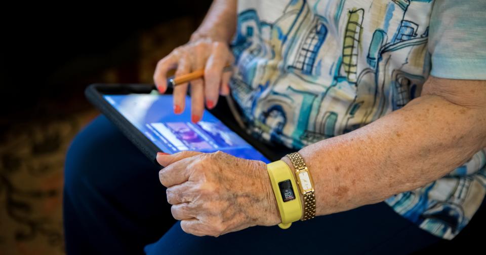 Resident using her iPad and wearing a smart watch.