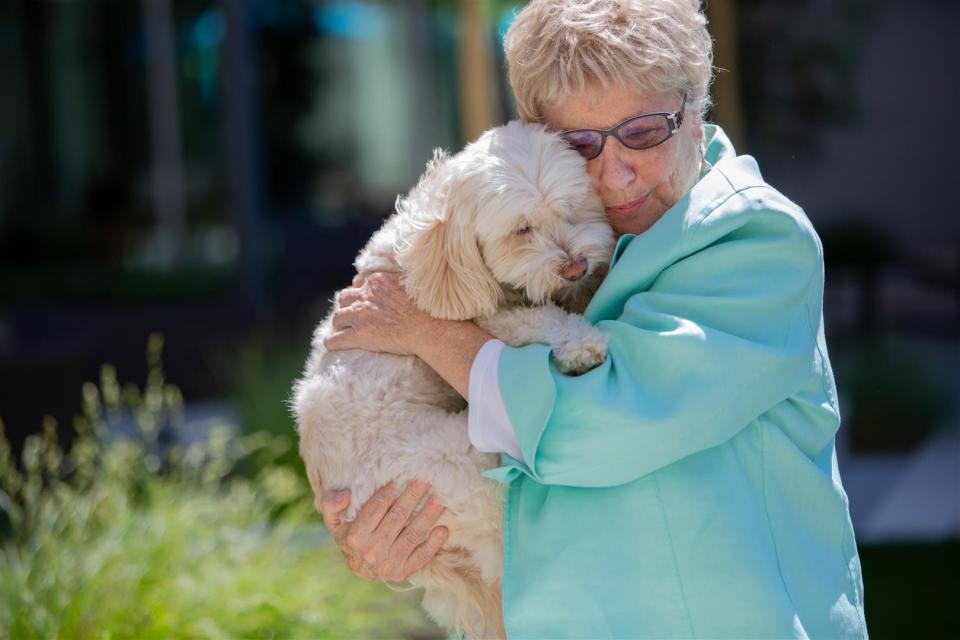 Resident holding and hugging her dog