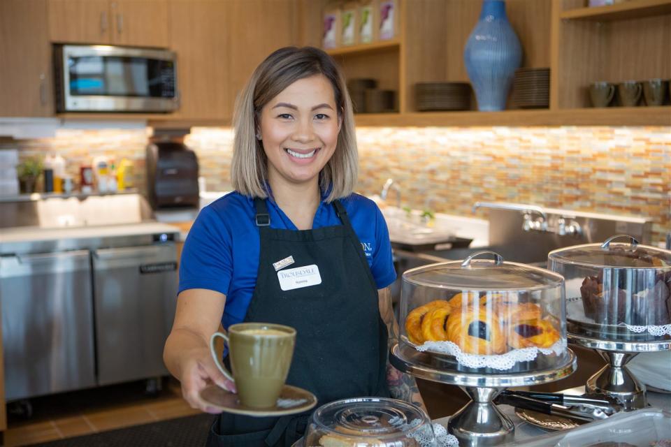 Staff offering a cup of coffee at the Bistro Cafe
