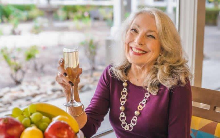 Woman  holding a glass of champagne, smiling.