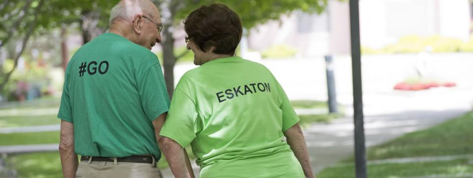 Residents taking a walk, holding hands and wearing Go Eskaton t-shirts